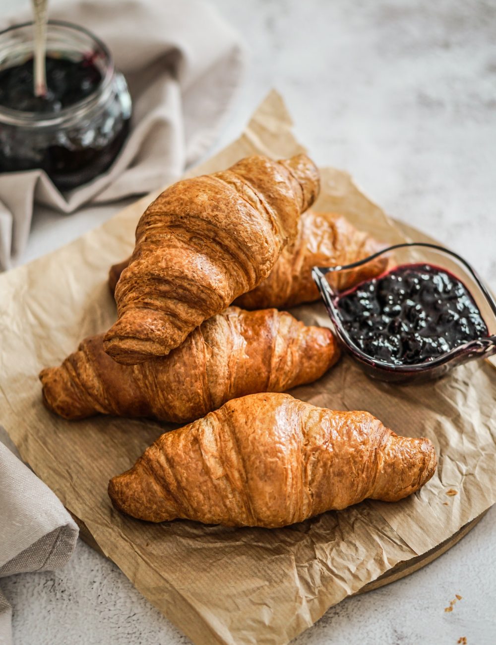 french-fresh-croissant-with-blackberry-jam-on-a-bakery-paper-and-grey-background.jpg